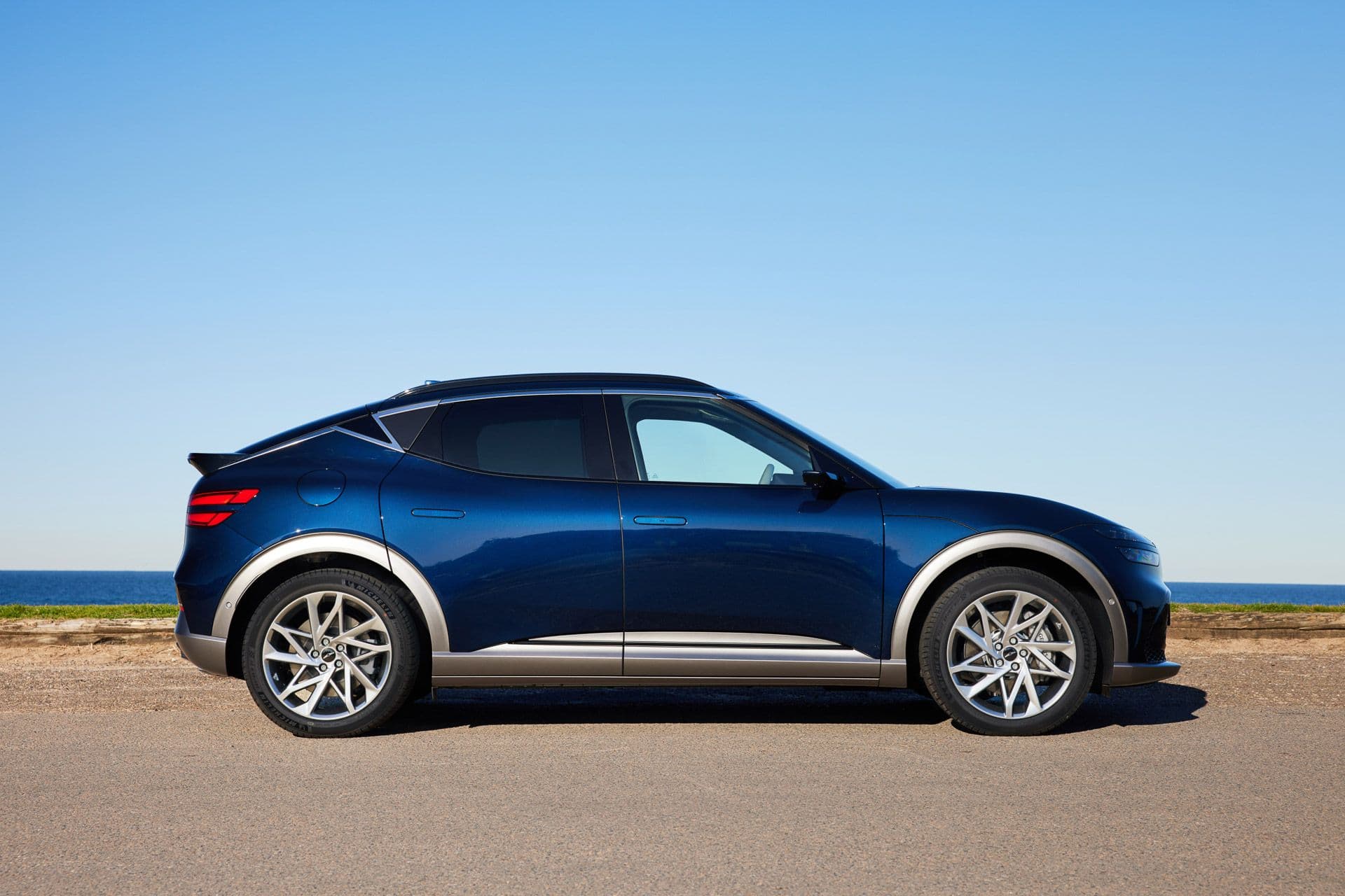 Dark blue Genesis GV60 AWD side view Dark blue Genesis GV60 AWD side view