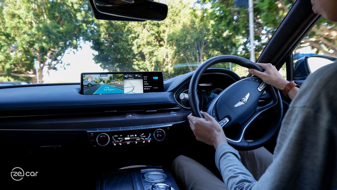 Man driving Genesis Electrified G80 with AR navigation enabled Man driving Genesis Electrified G80 with AR navigation enabled
