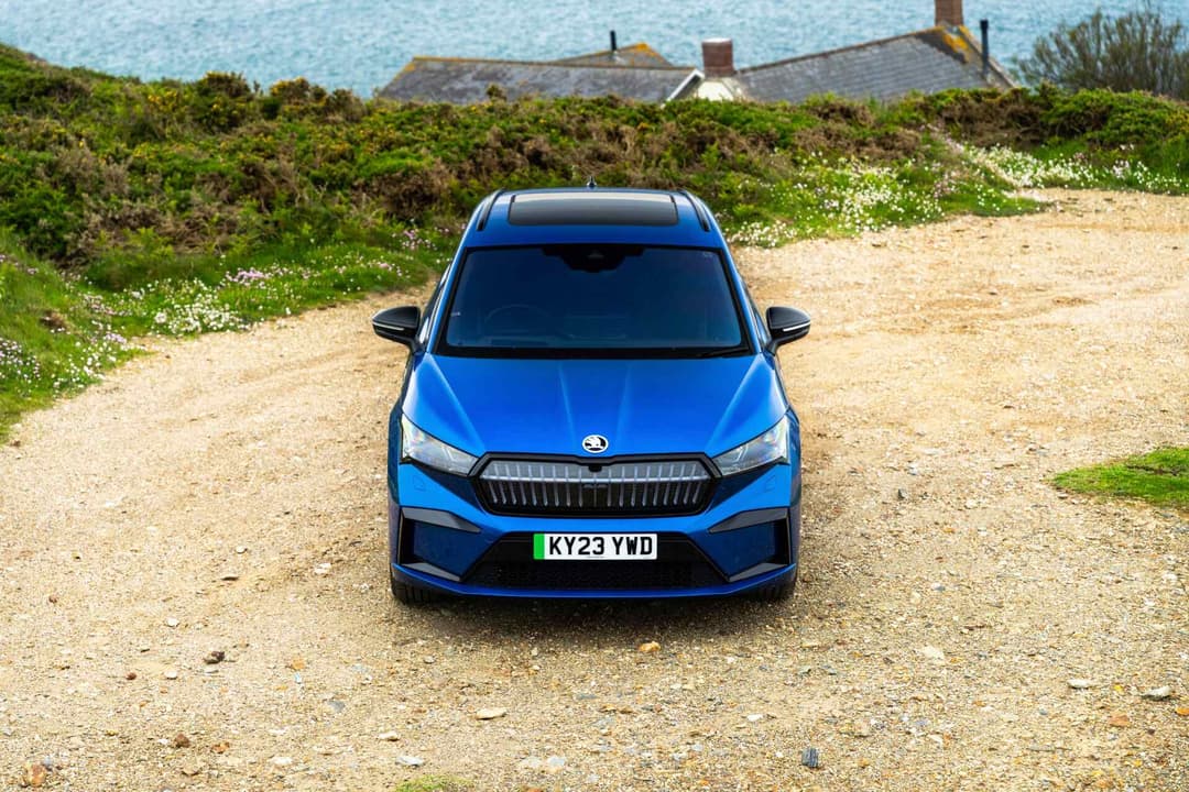 Skoda Enyaq blue parked with sea background Skoda Enyaq blue parked with sea background