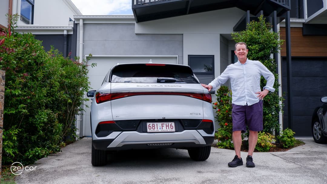 Man standing next to white BYD Atto 3 rear Man standing next to white BYD Atto 3 rear