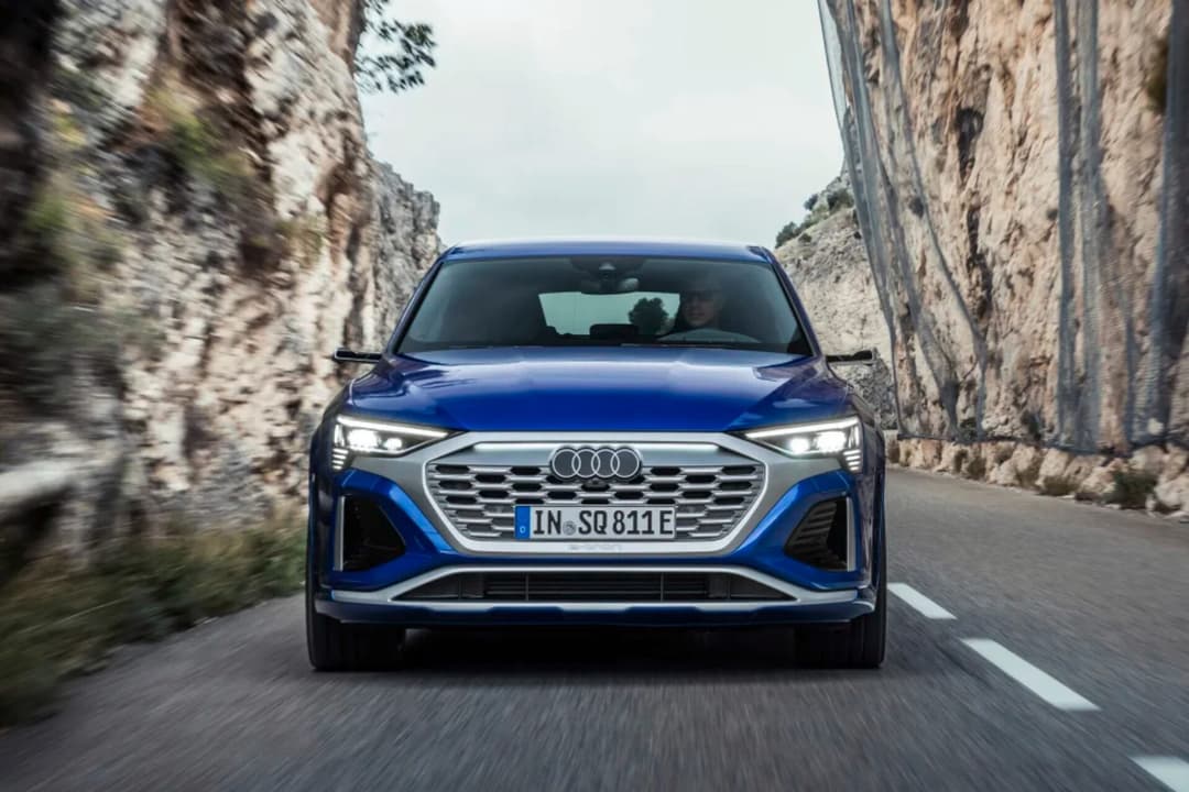Audi SQ8 in blue front view driving on road Audi SQ8 in blue front view driving on road