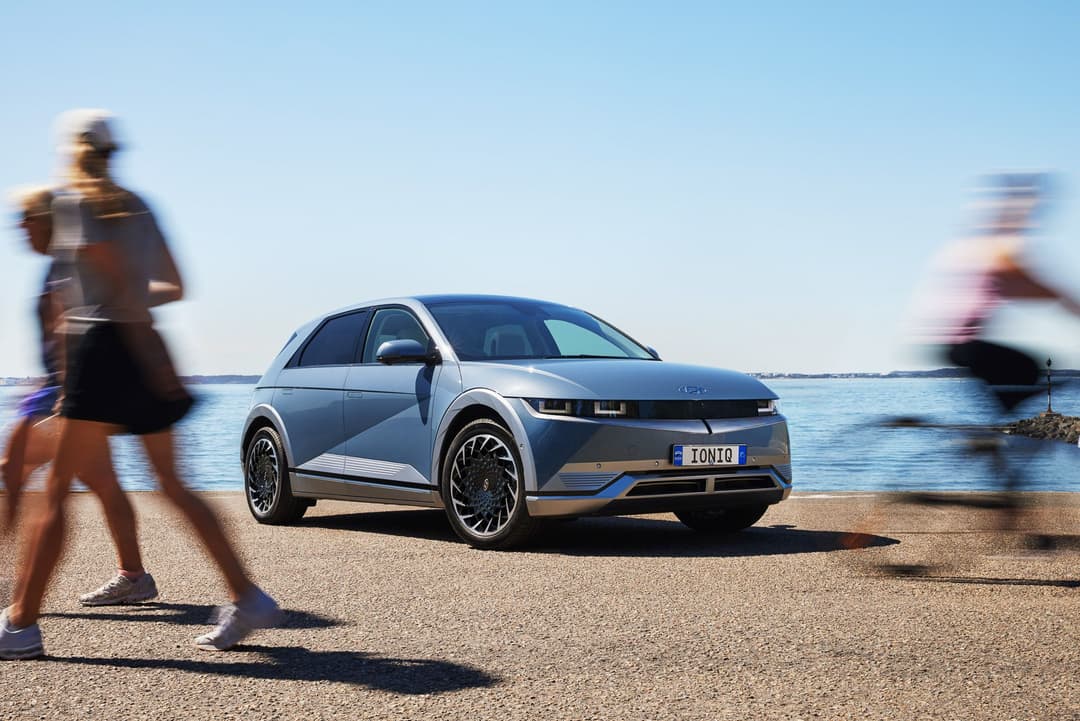 People pass by blue Hyundai Ioniq 5 People pass by blue Hyundai Ioniq 5