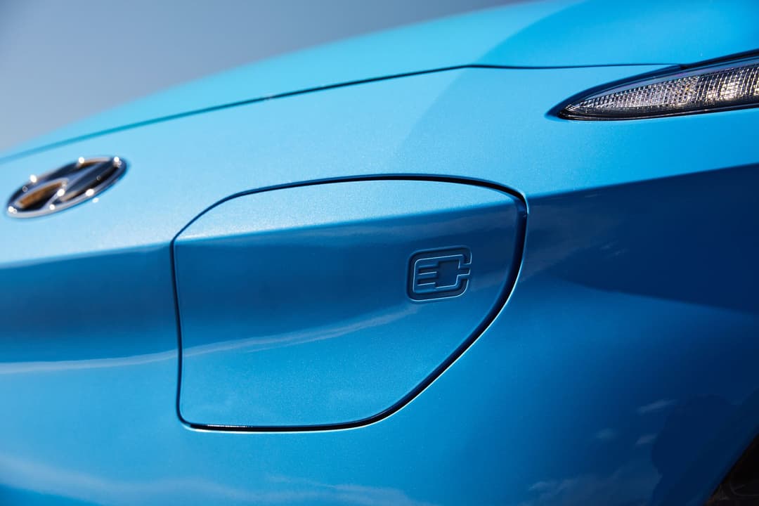 Blue Hyundai Kona Electric closed front charging port lid with plug logo Blue Hyundai Kona Electric closed front charging port lid with plug logo