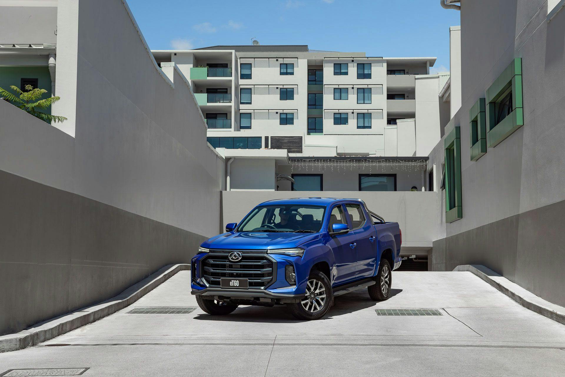 Blue LDV eT60 electric ute in front of urban apartments