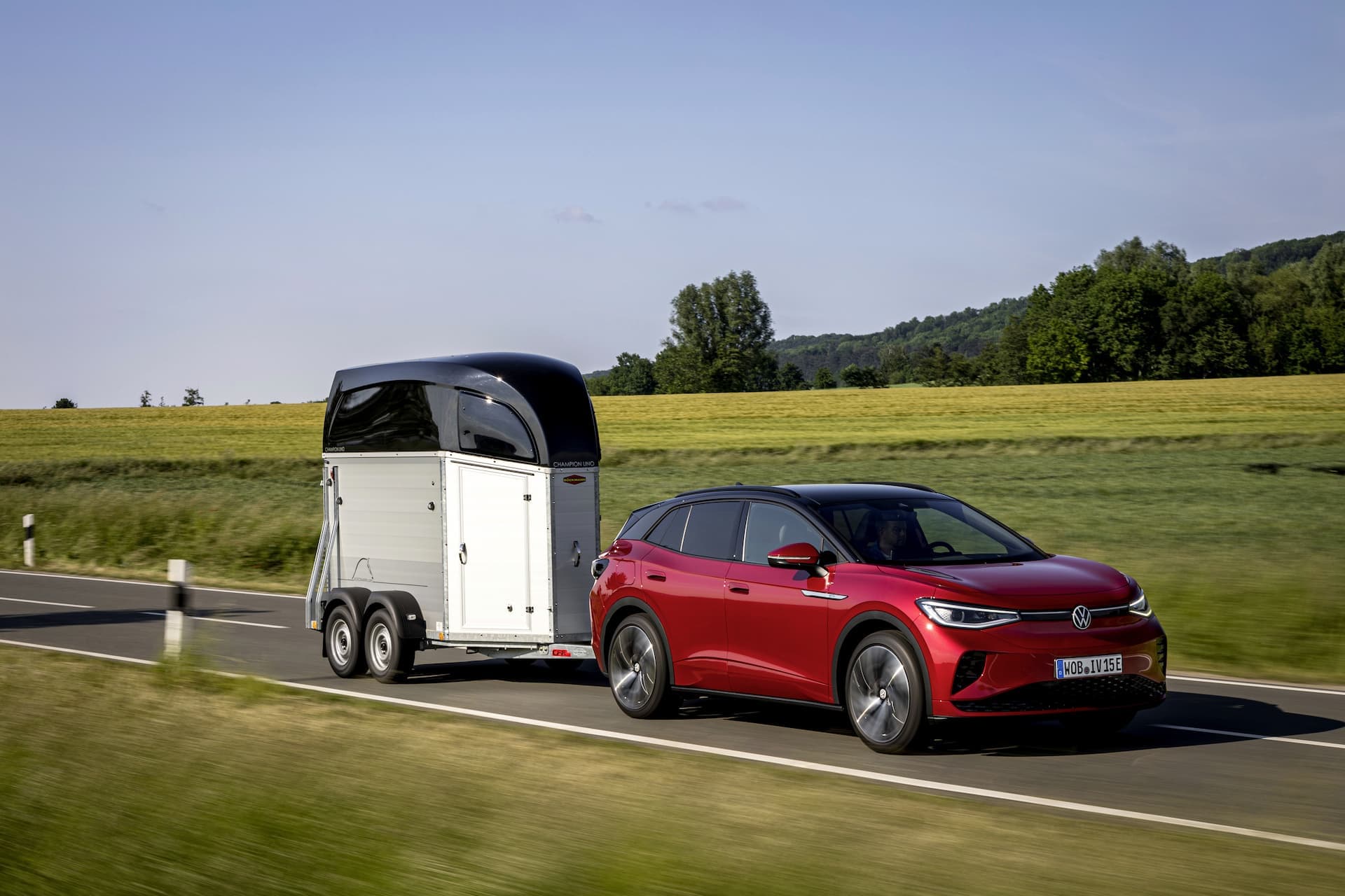 Red Volkswagen ID.4 GTX EV SUV towing Red Volkswagen ID.4 GTX EV SUV towing
