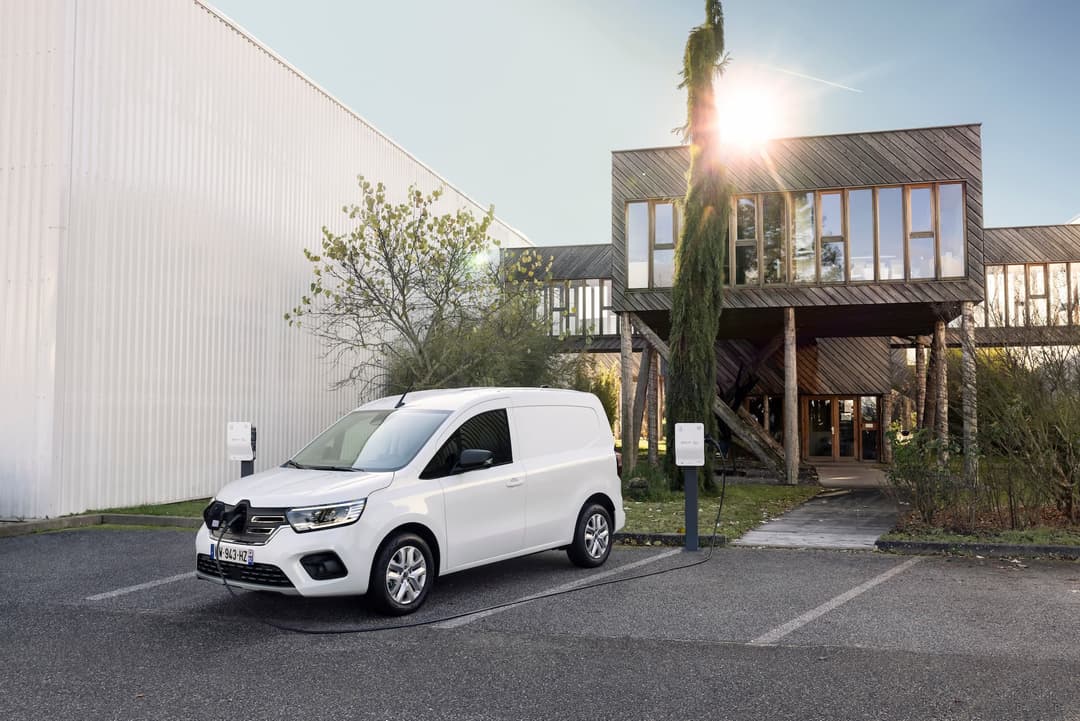 White Renault Kangoo E-Tech van charging in front of house White Renault Kangoo E-Tech van charging in front of house