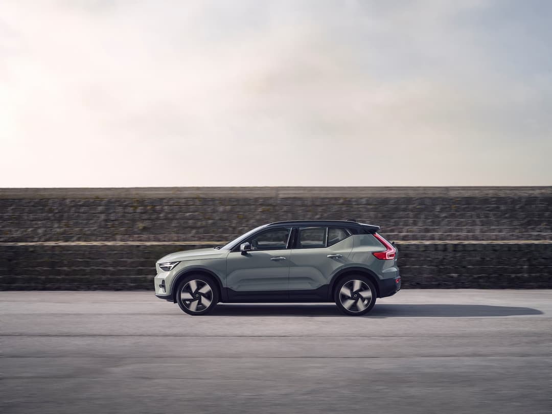 Green Volvo XC40 Recharge EV driving side view Green Volvo XC40 Recharge EV driving side view