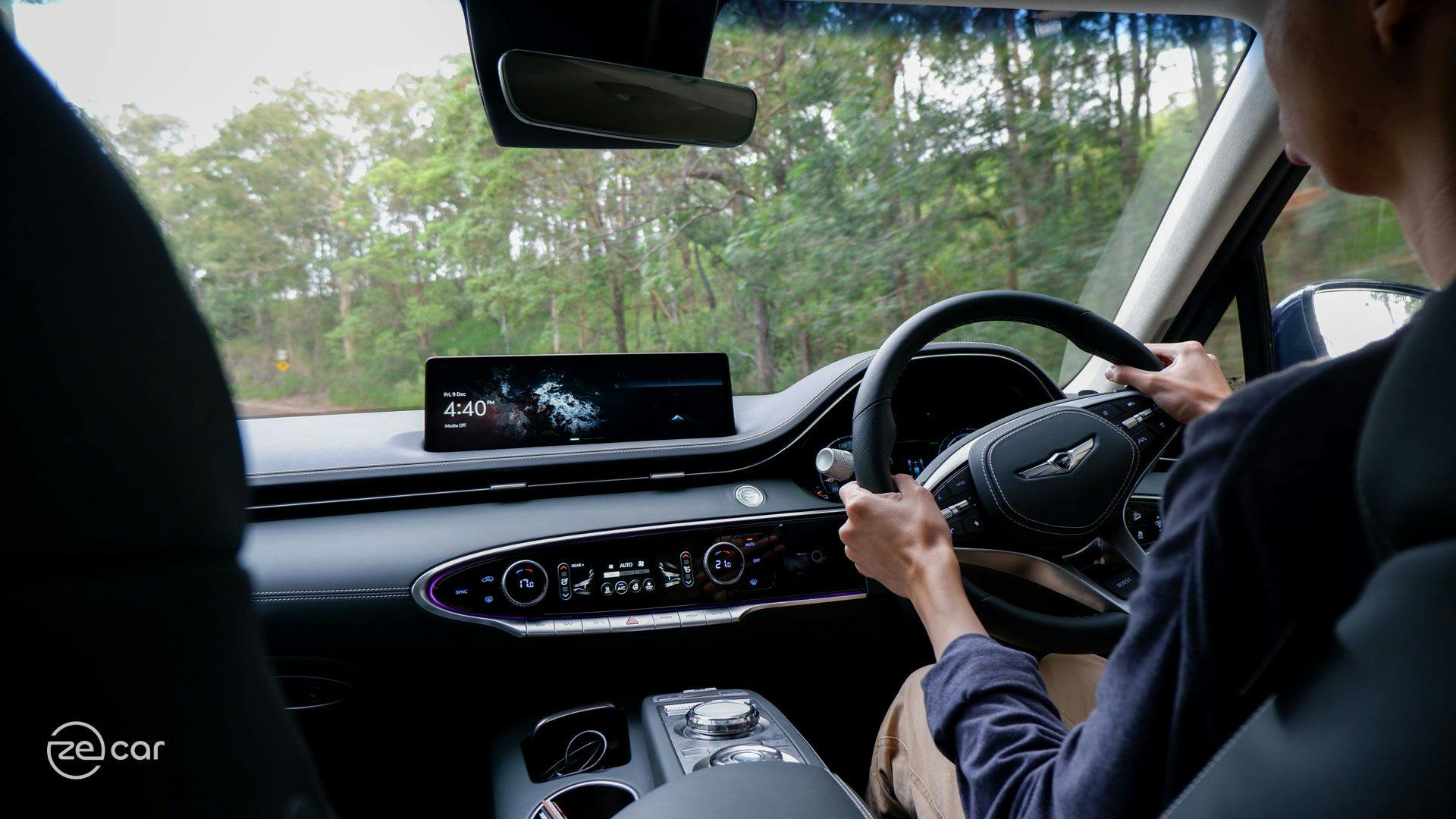 Man driving Genesis Electrified GV70 in forest interior view