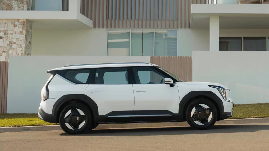 2024 Kia EV9 side view with modern house background 2024 Kia EV9 side view with modern house background