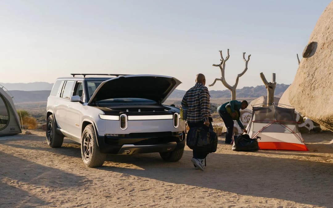 White Rivian R1S with frunk open in camp White Rivian R1S with frunk open in camp