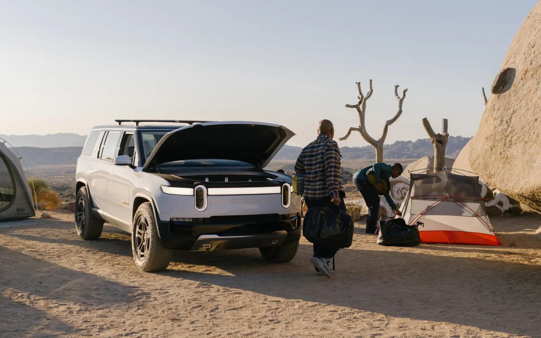White Rivian R1S with frunk open in camp White Rivian R1S with frunk open in camp