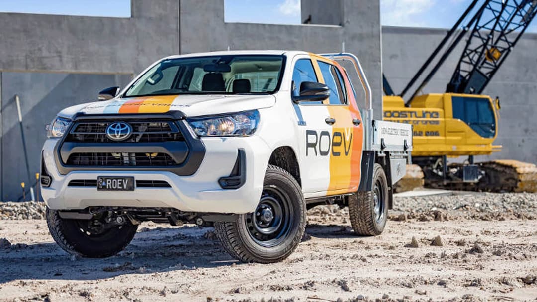 White ROEV Toyota Hilux in front of yellow crane at a construction site White ROEV Toyota Hilux in front of yellow crane at a construction site