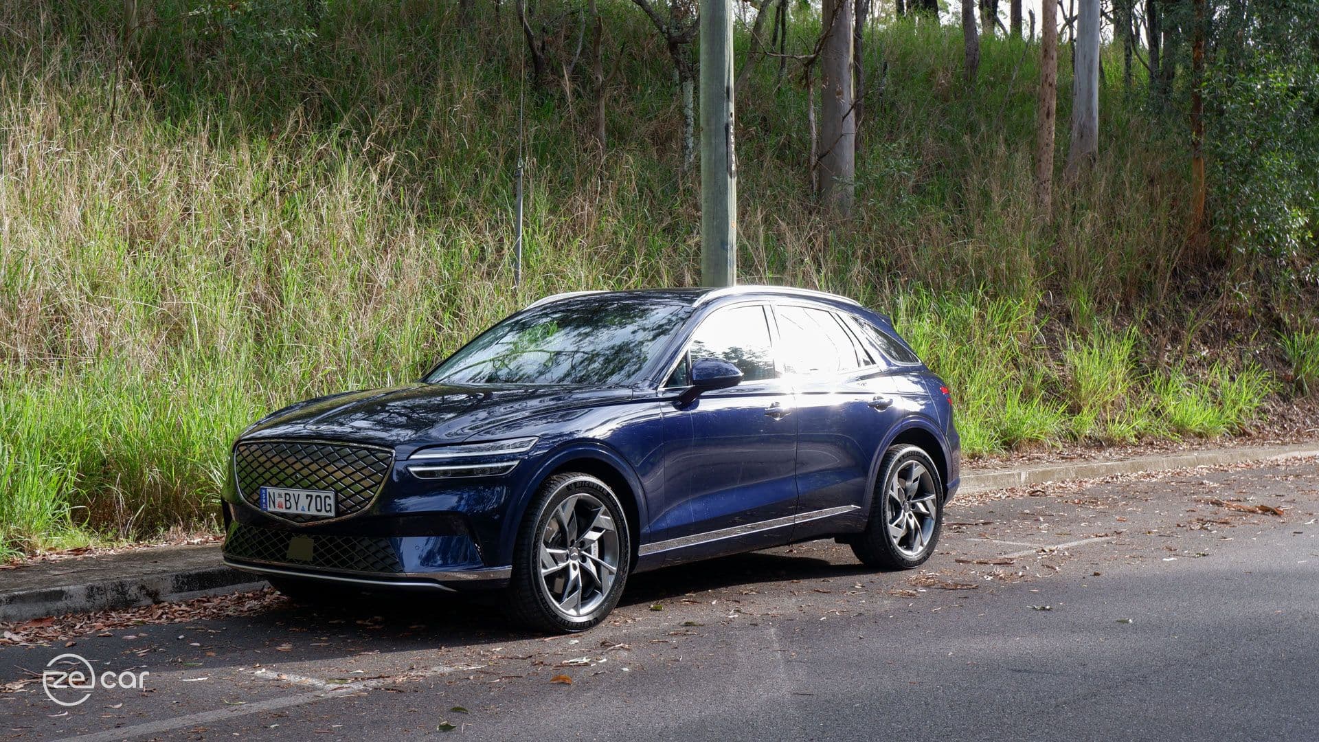 Genesis Electrified GV70 front three-quarter view on mountain scenic drive road sunset Genesis Electrified GV70 front three-quarter view on mountain scenic drive road sunset