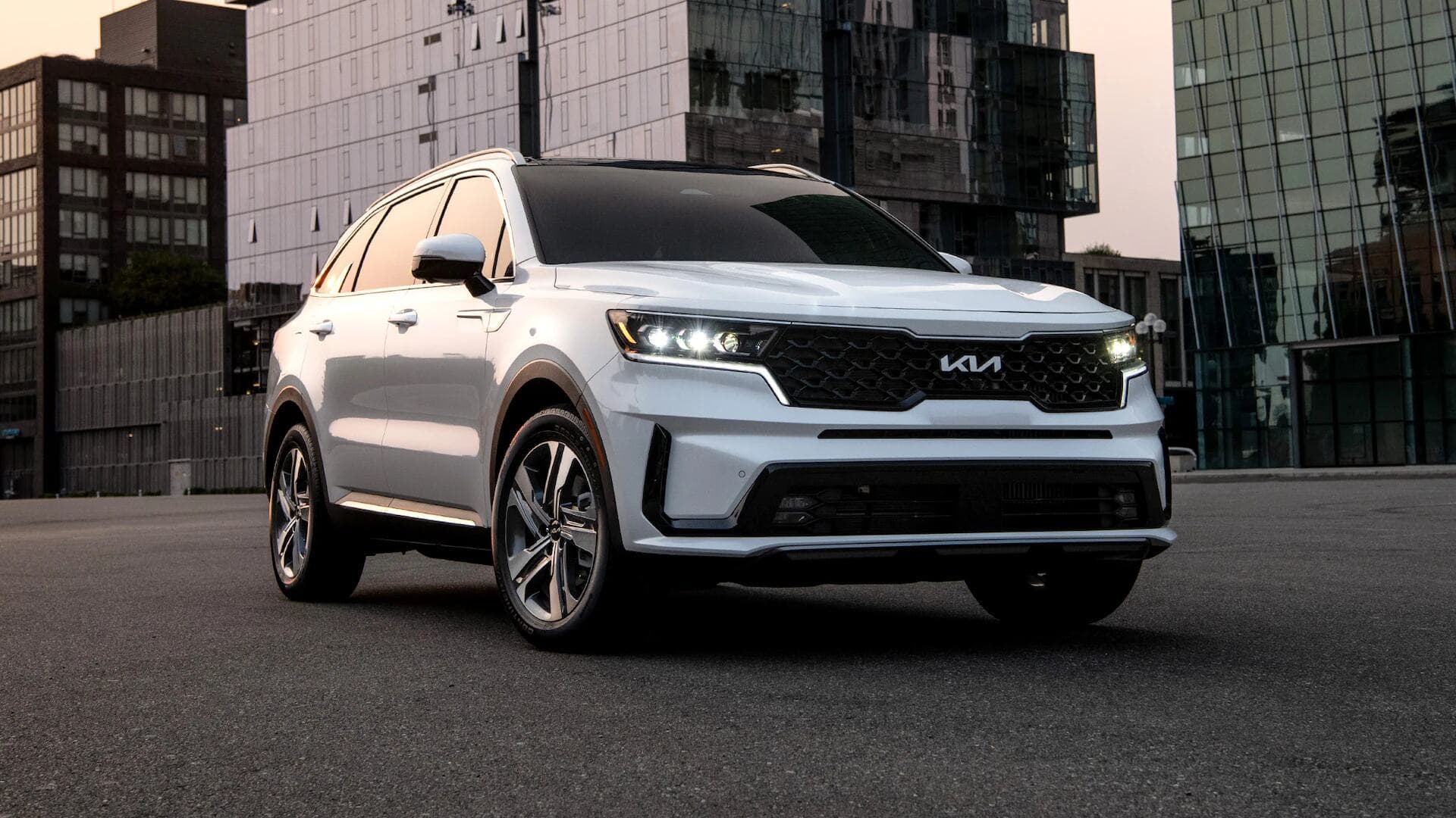Kia Sorento in white three quarter view driving on road Kia Sorento in white three quarter view driving on road