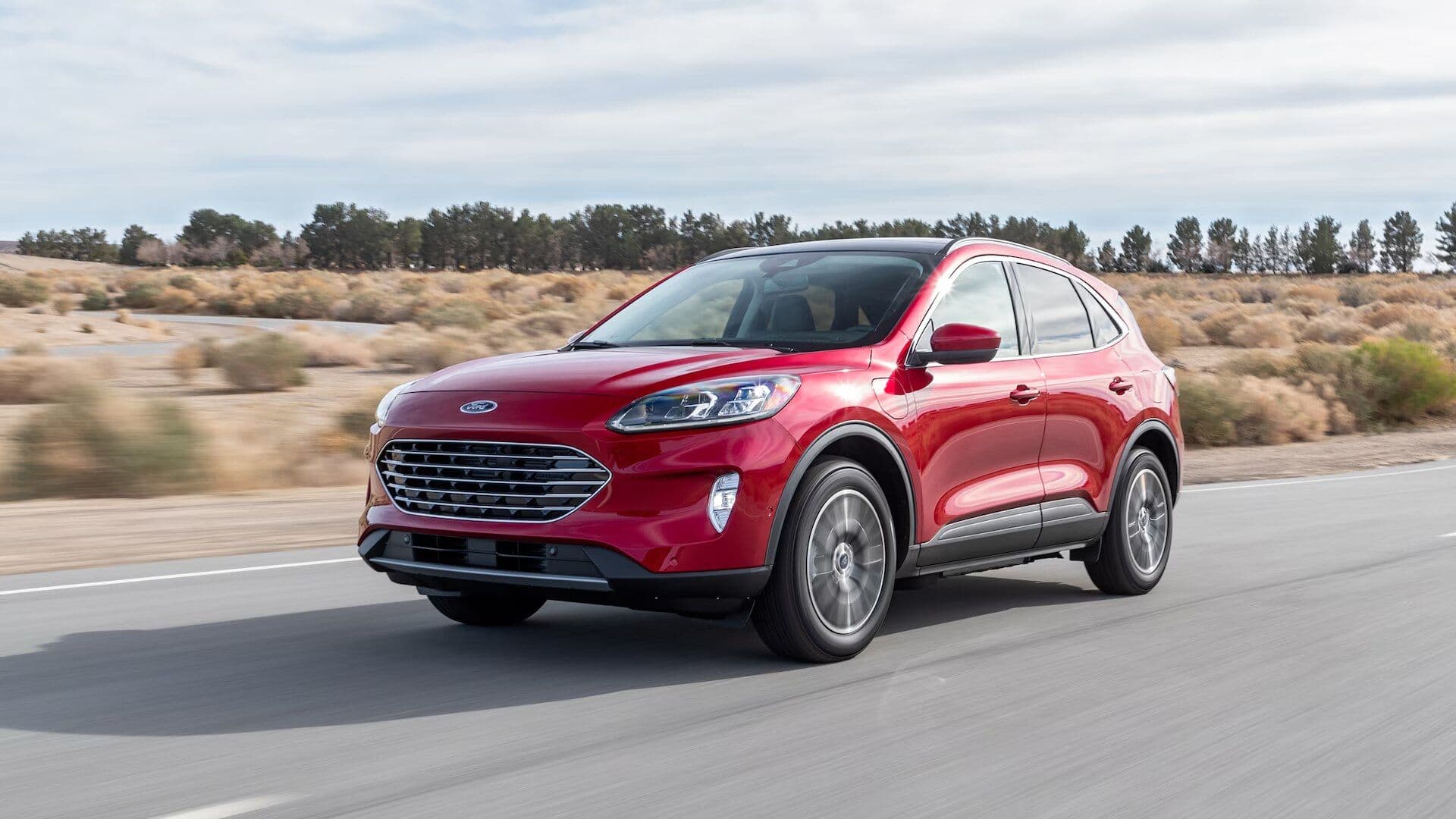 Ford Escape in red driving on road three quarter view Ford Escape in red driving on road three quarter view