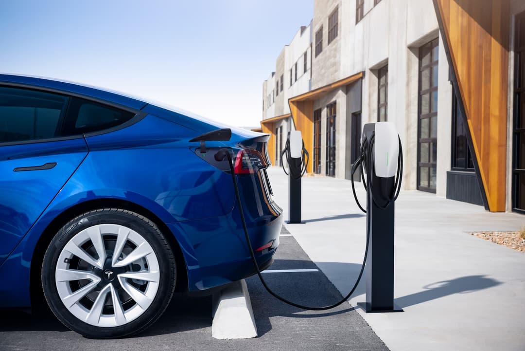 Tesla Model 3 charging at wall box and BYD Atto 3 rear