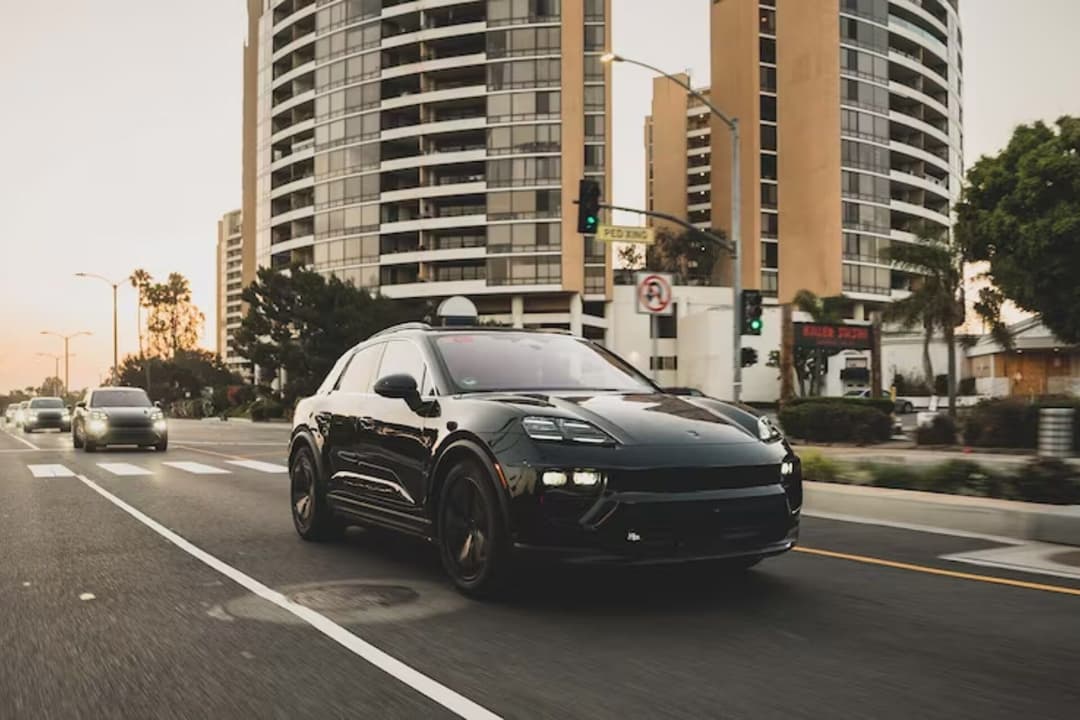 Porsche Macan in black driving at city road Porsche Macan in black driving at city road