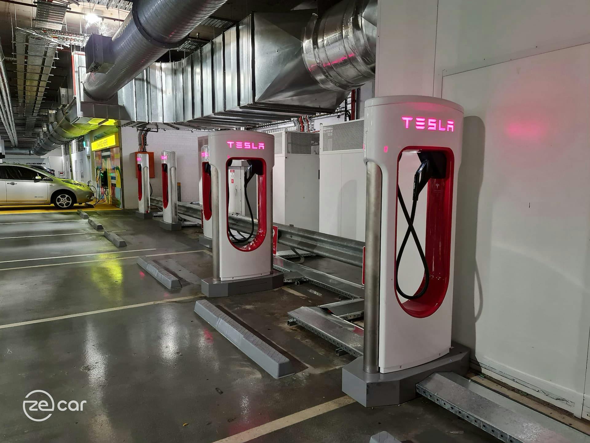 Six Tesla Superchargers next to charging Nissan Leaf in Toombul car park