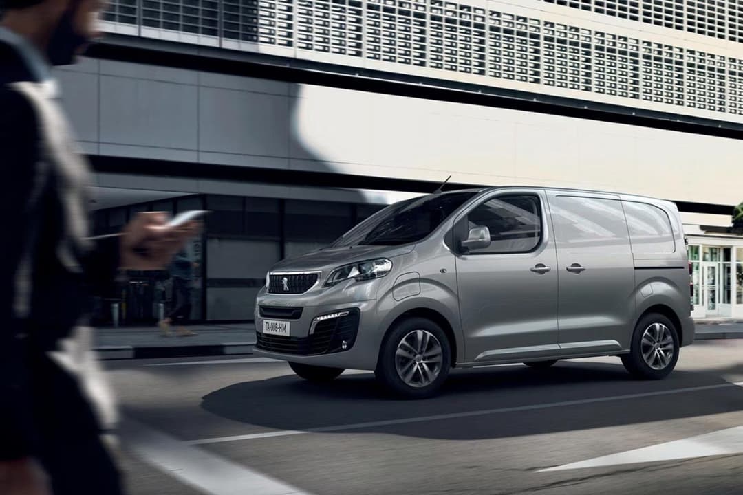 Peugeot e-Expert in grey driving at city Peugeot e-Expert in grey driving at city