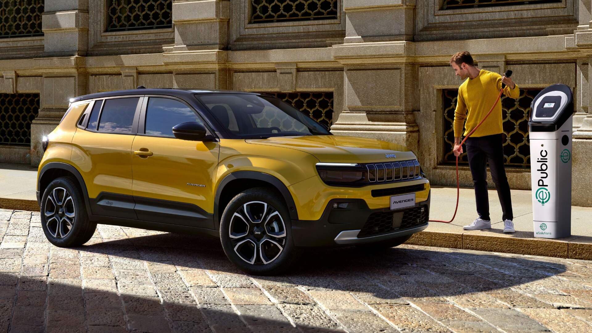 2025 Jeep Avenger in gold side view charging in public 2025 Jeep Avenger in gold side view charging in public