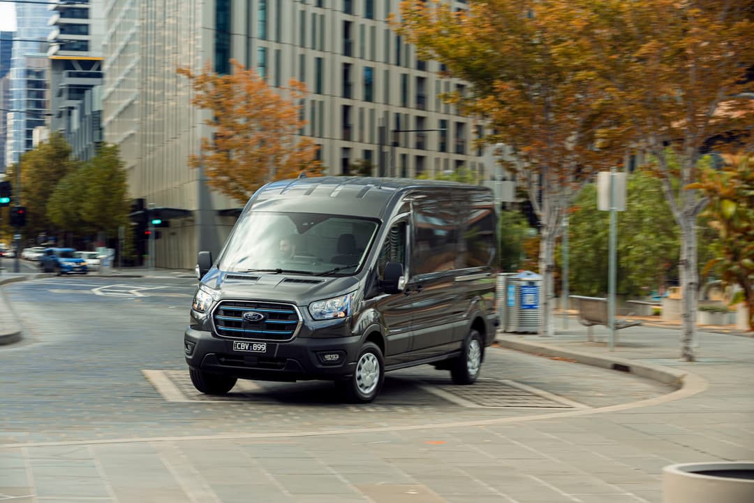 Grey Ford E-Transit driving in city Grey Ford E-Transit driving in city