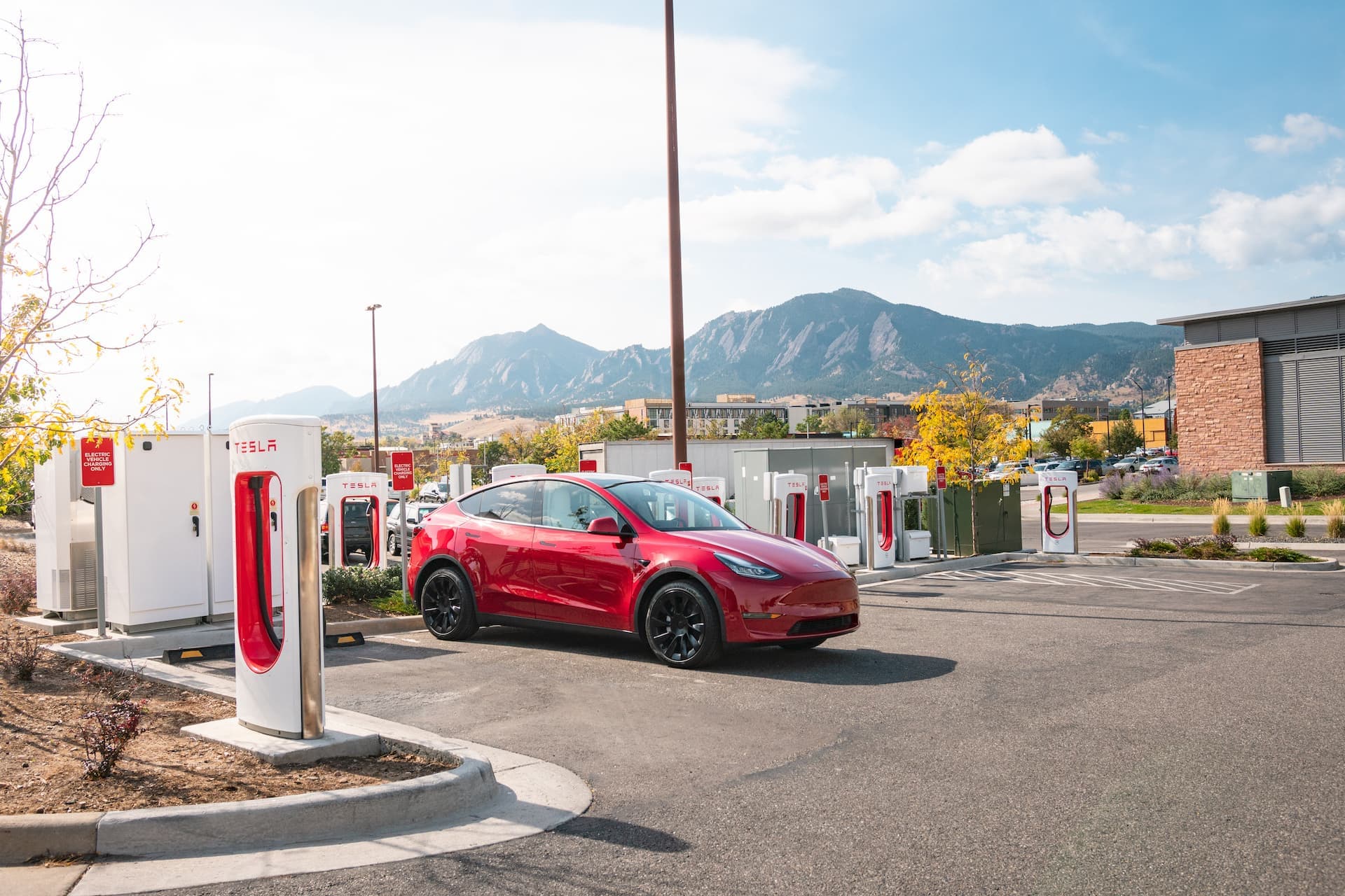 Red Tesla Model Y at Supercharging station Red Tesla Model Y at Supercharging station