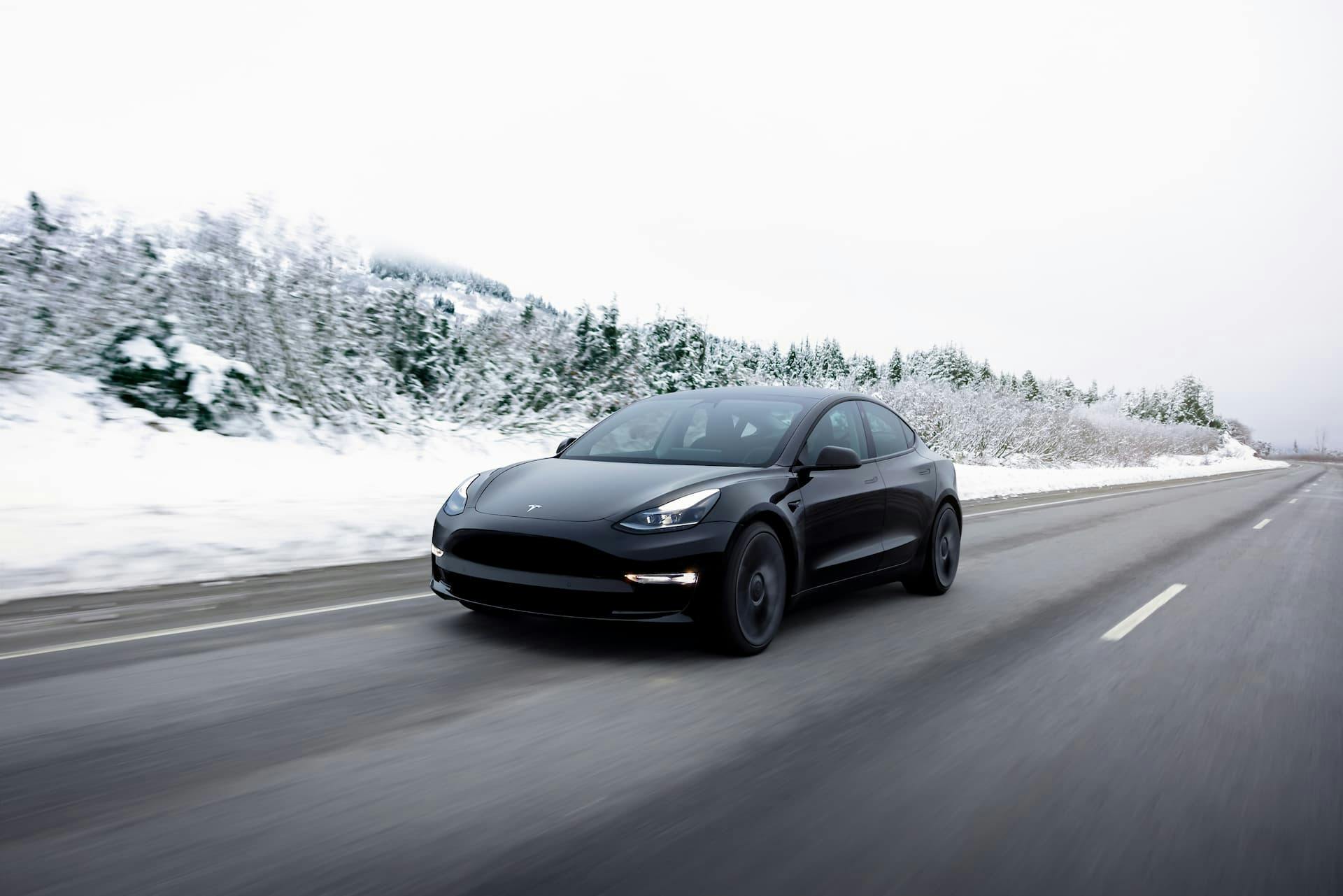 Black Tesla Model 3 Performance driving in snow