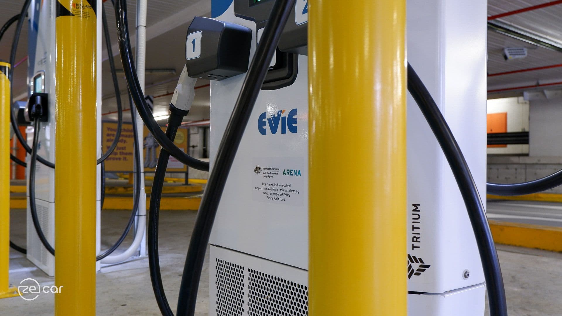 Evie Networks, Tritium and ARENA logos on EV charger Evie Networks, Tritium and ARENA logos on EV charger