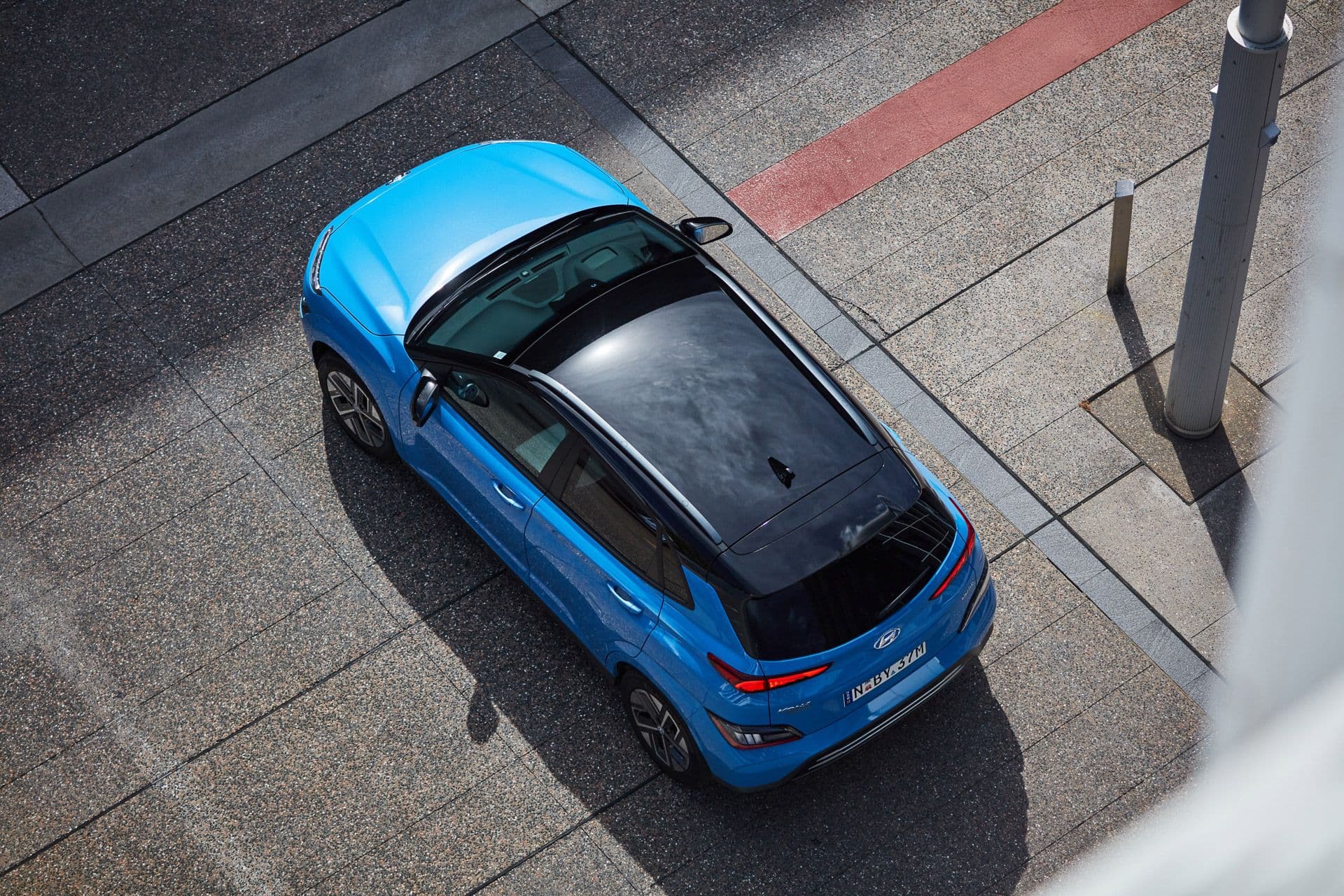 Blue Hyundai Kona Electric with black roof top-down view Blue Hyundai Kona Electric with black roof top-down view