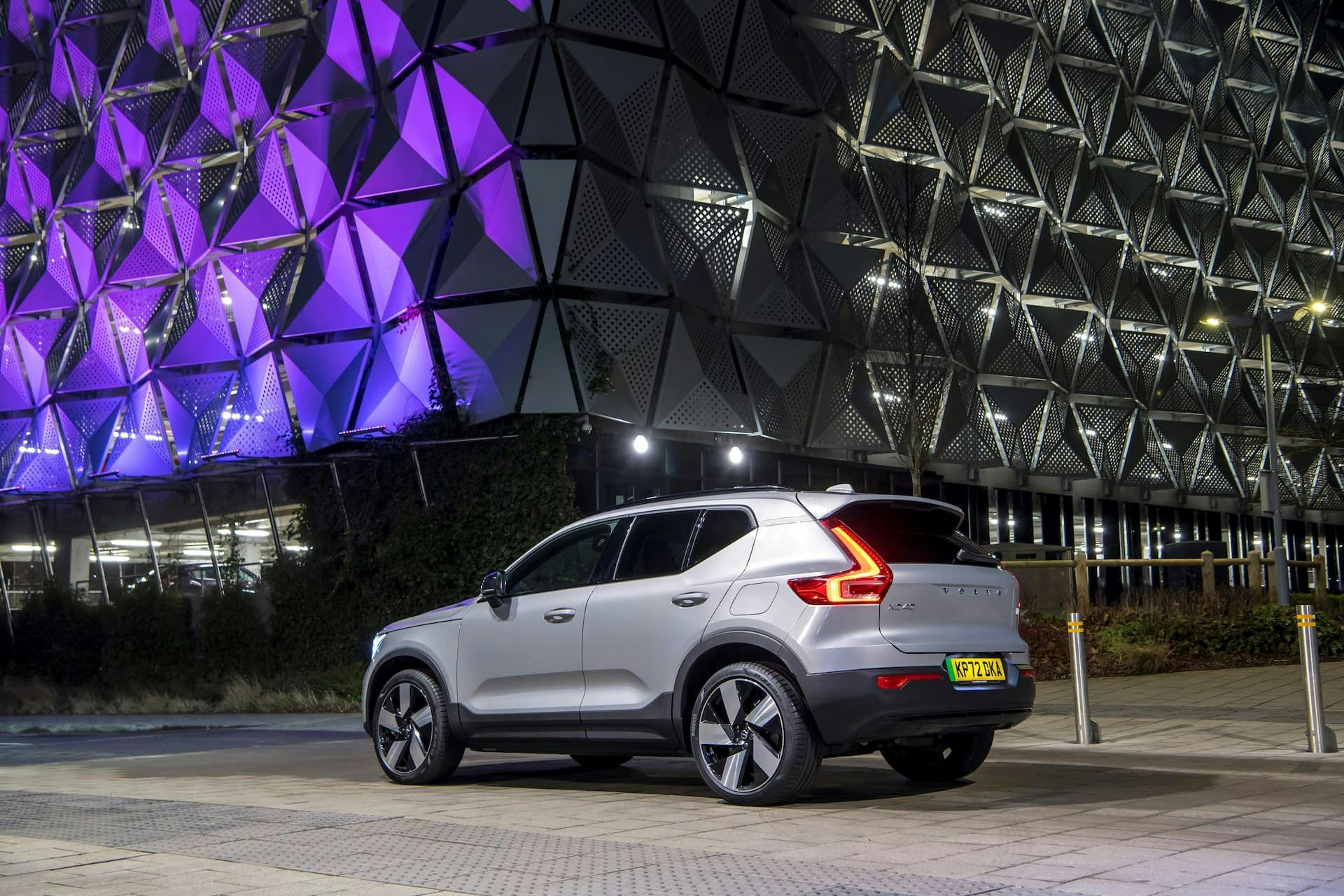 Volvo XC40 Recharge in front of purple building at night rear view